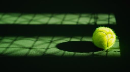 een-nieuwe-tennisbal-en-netto-schaduw-op-groen-hardcourt-met-licht-van-rechts_34939-458.jpg